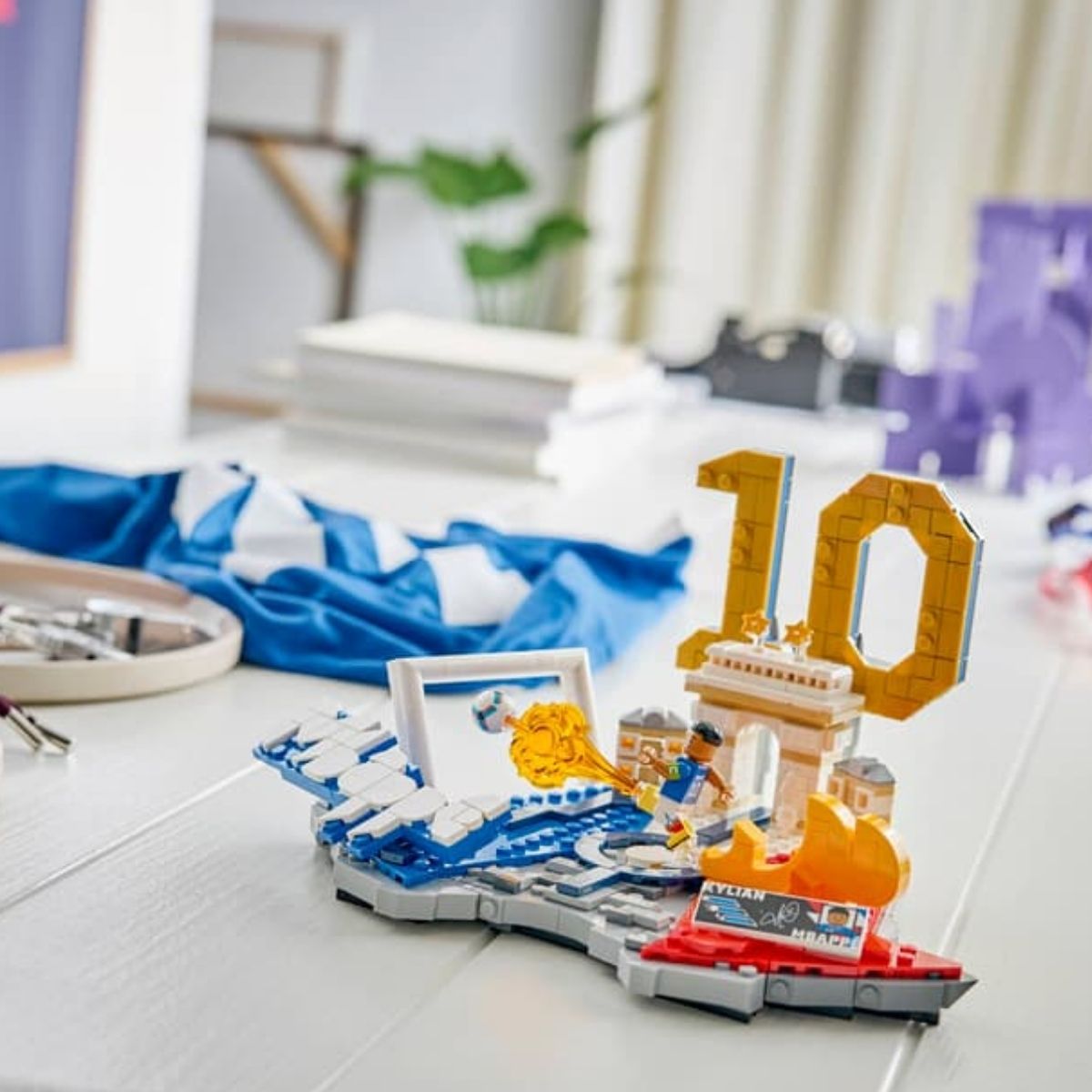 The completed LEGO® Kylian Mbappé soccer highlights display piece styled elegantly on a clean white table.