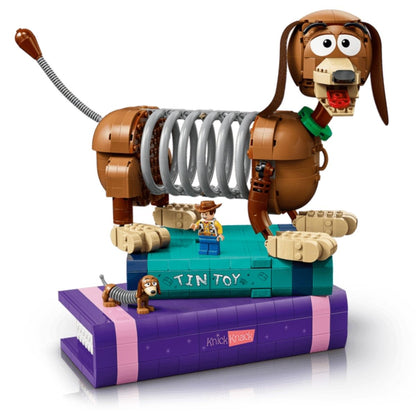 The completed LEGO Slinky Dog model fully assembled and sitting on top of the two brick-built purple and teal display books.