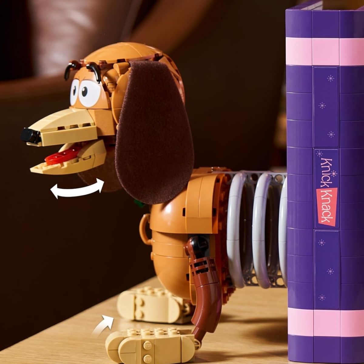 Close-up shot showing a hand turning the back panel of the purple book to actuate the hidden movie scene.