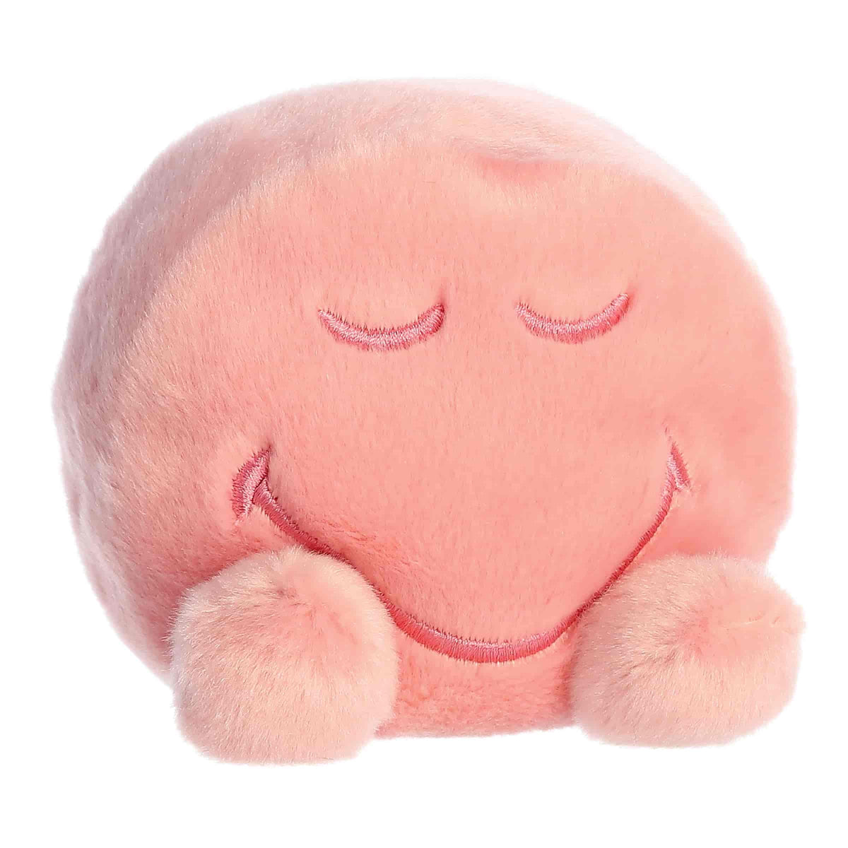 Front angled view of the 5-inch Aurora Palm Pals SmileyWorld Zen plush toy featuring a round pastel pink body with closed eyes and a gentle smile.