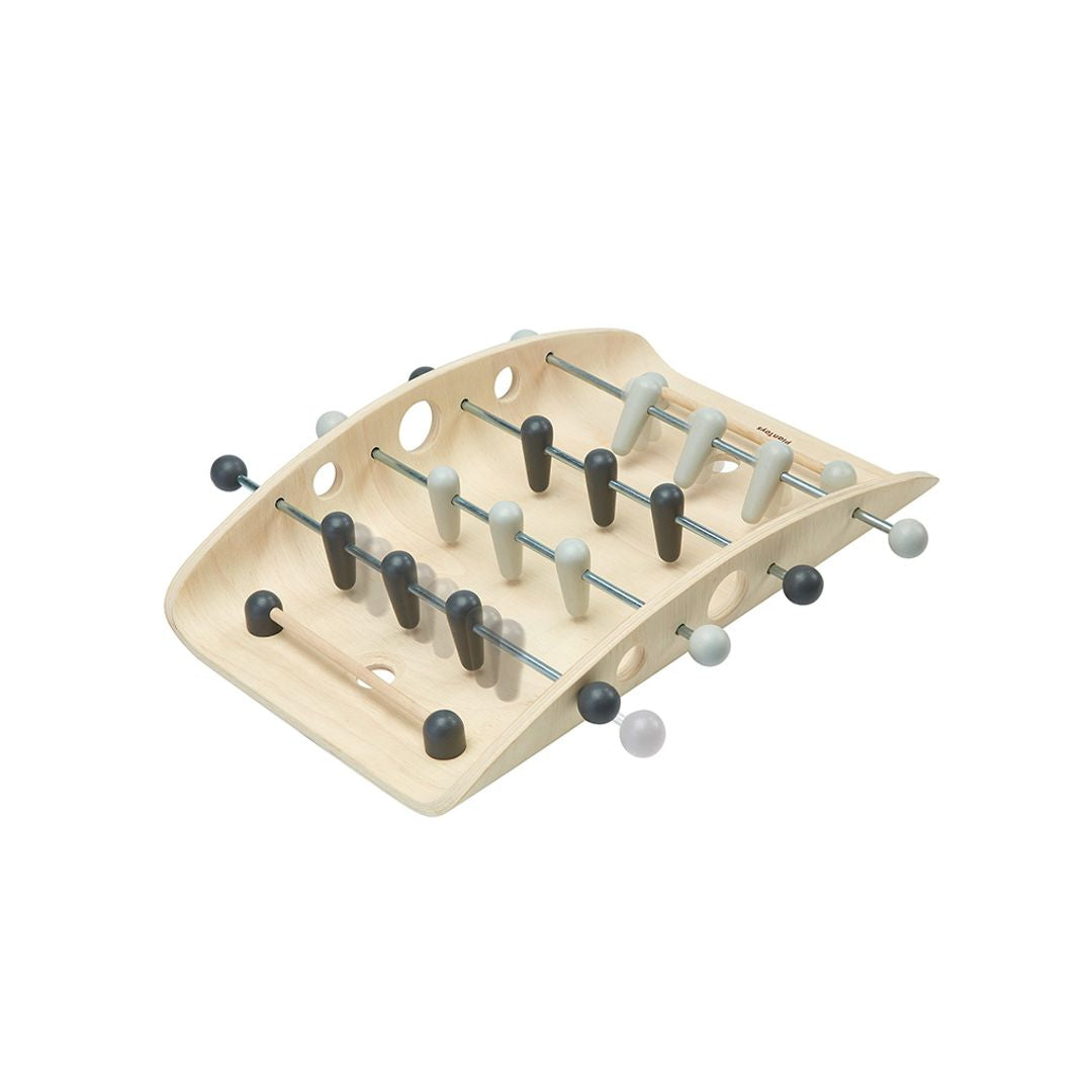 Angled view of the non-toxic PlanToys wooden soccer toy showing its unique ball-returning curved design.
