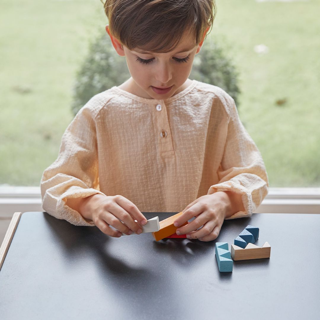 A little one practicing problem-solving skills with the compact PlanMini rectangular brain teaser.