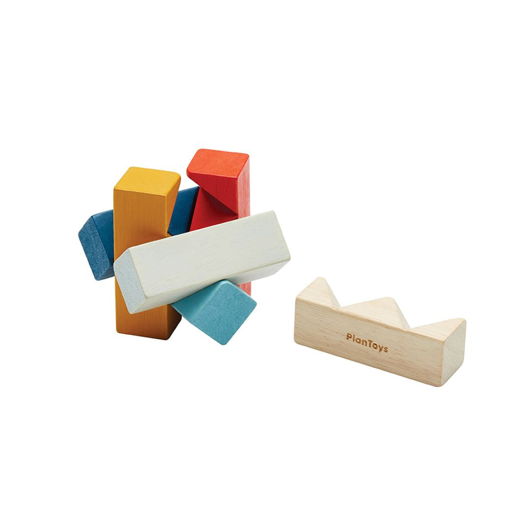 Overhead view of the PlanToys PlanMini rectangular puzzle taken apart to show the individual non-toxic wooden geometric pieces.