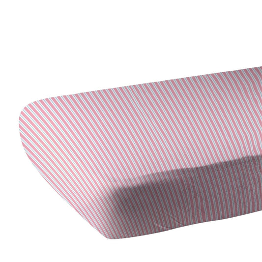 Close-up of the pink and white pinstripe bamboo muslin fabric showing the fitted corner of the crib sheet.