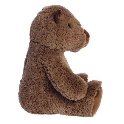 Side profile view of the capybara plush sitting down, highlighting its relaxed posture and fluffy texture.