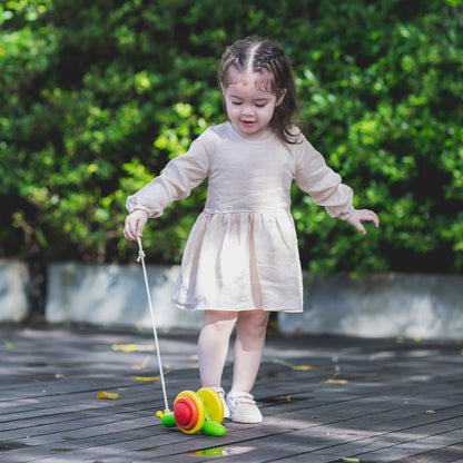 Child engaging and pulling the PlanToys wooden pull-along snail toy 
