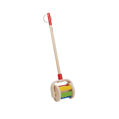 Angled view of the sustainable PlanToys walk and roll toy highlighting the long handle and rolling drum with colorful blocks.