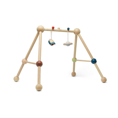 Side profile view showcasing the sturdy four-leg A-frame design of the PlanToys baby play gym for maximum safety.