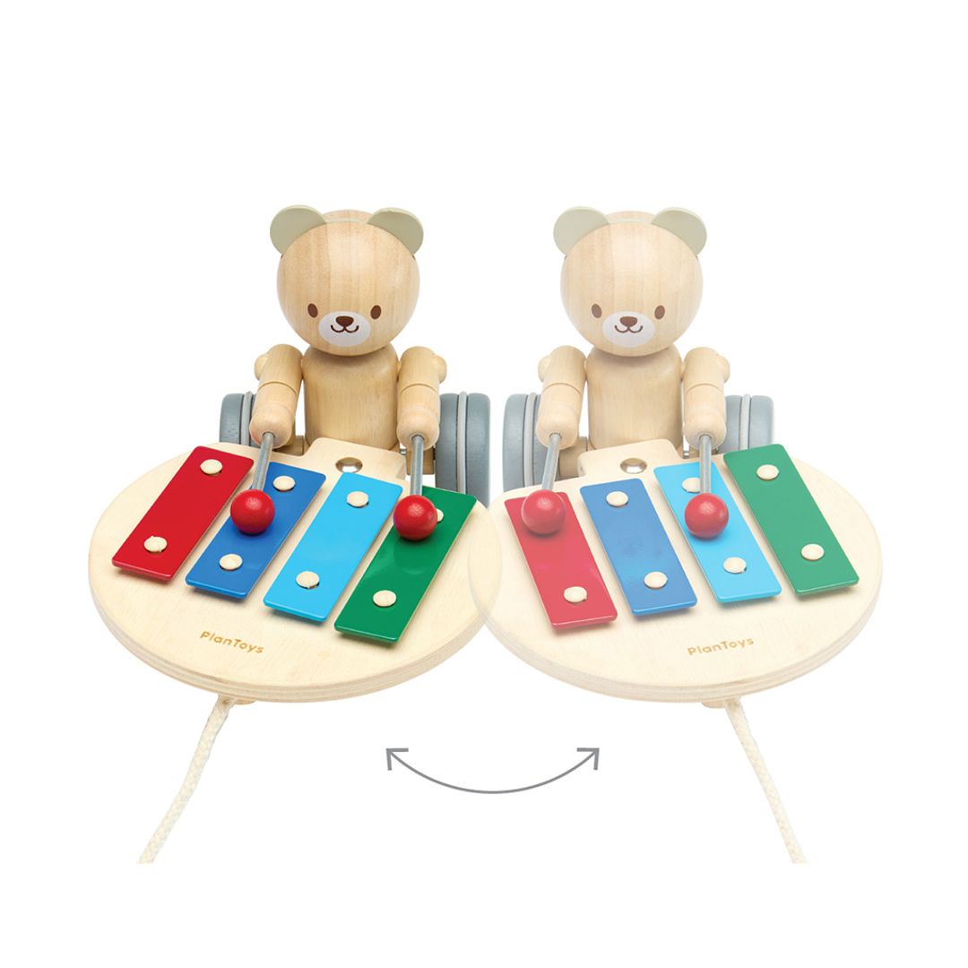 A graphic showing the movement drumming motion of the PlanToys wooden bear's arms as it rolls.