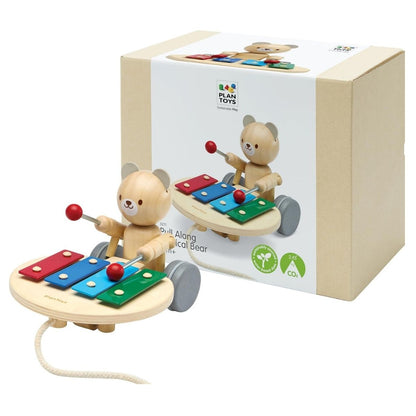 The PlanToys wooden pull along musical bear displayed next to its eco-friendly, sustainable cardboard packaging.