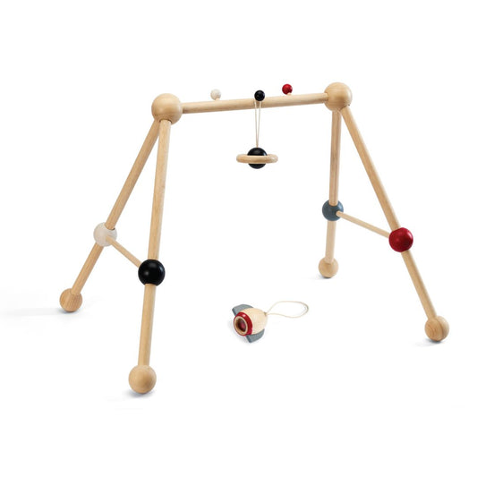 The sustainable PlanToys high contrast infant activity center showing one hanging wooden toy and one detached for hands-on floor play.