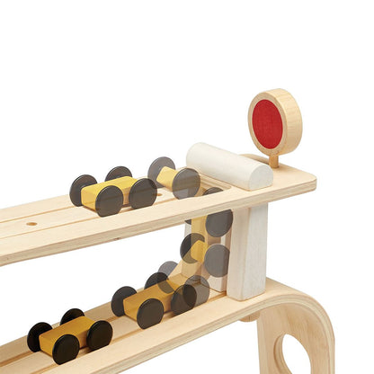 Graphic demonstrating how the wooden toy cars flip and race down the levels of the PlanToys ramp racer.