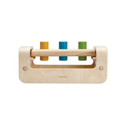 Front angle of the chemical-free rubberwood PlanToys pounding bench showing the three vibrant pegs.