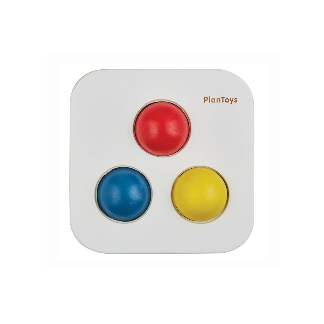 Top-down view of the PlanToys wooden bin showing the three vibrantly colored holes.