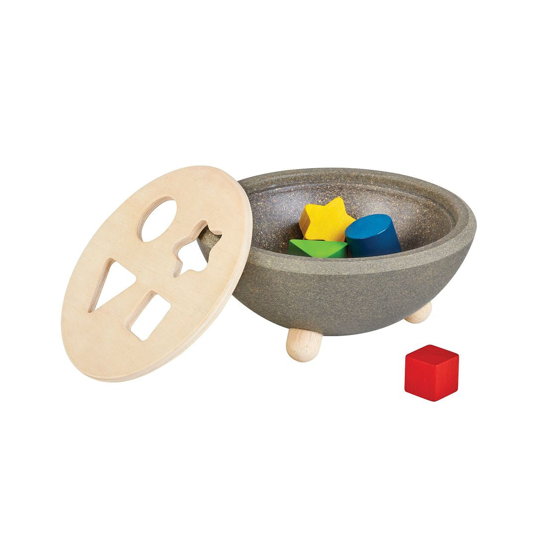 The eco-friendly PlanWood sorting bowl shown with the lid removed to reveal the colorful wooden blocks inside.