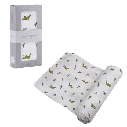 Partially unrolled Newcastle Classics Pteranodon cotton muslin swaddle blanket displayed next to its grey window packaging box.