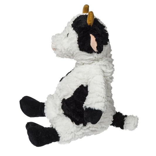 Side view of the slouchy Snuggables cow plush showing its weighted bottom and soft spotted fabric.