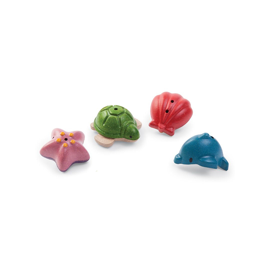 Detailed view of the four chemical-free PlanToys ocean bath toys resting together on a clean white surface.
