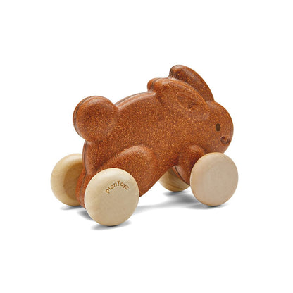Side profile of the durable brown PlanToys push along bunny showcasing its solid rubberwood wheels and safe, rounded edges.