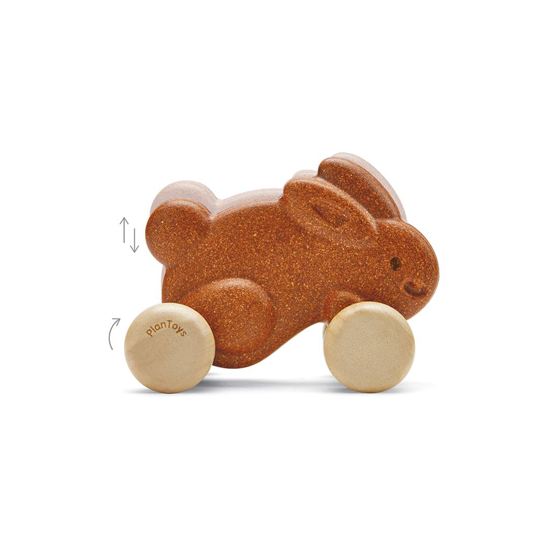 Graphic demonstrating the up-and-down hopping motion of the PlanToys wooden push along bunny as it rolls.