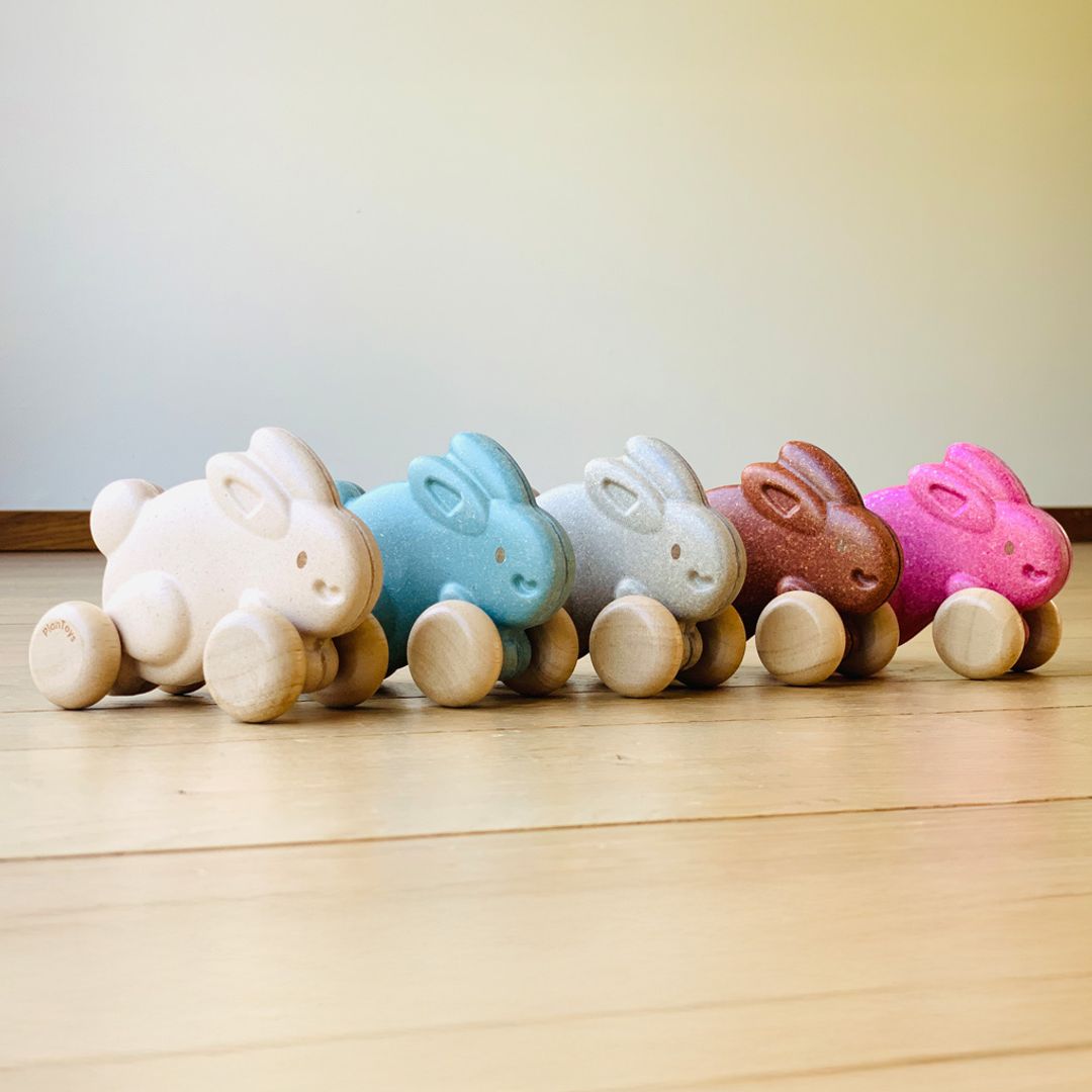 The complete collection of PlanToys wooden push along bunnies showcasing all the different non-toxic color variations.