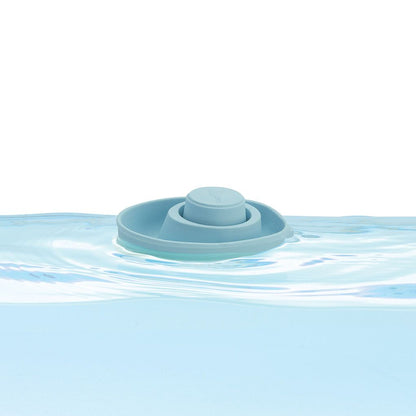 The PlanToys pastel blue flexible rubber convertible boat floating smoothly on clear water.