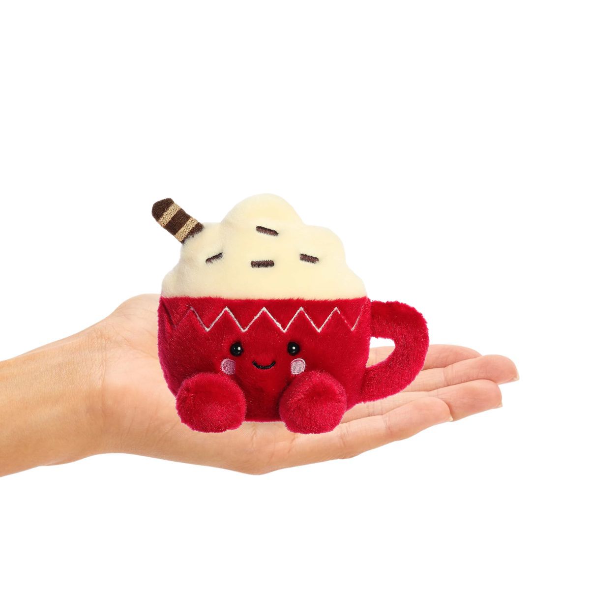 Plush toy resembling a cup of hot cocoa held in a hand on a white background