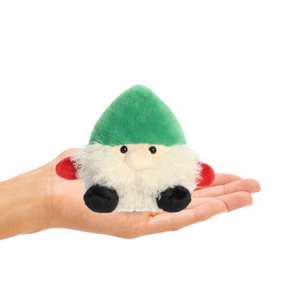 Small plush gnome held in a hand on a white background