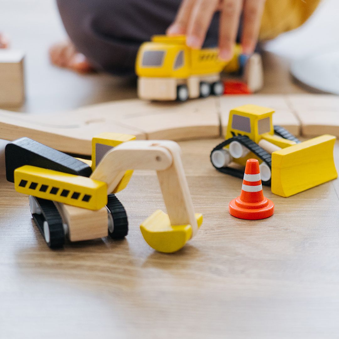 Close-up lifestyle shot highlighting the non-toxic, water-based dye finish on the PlanToys wooden toy.