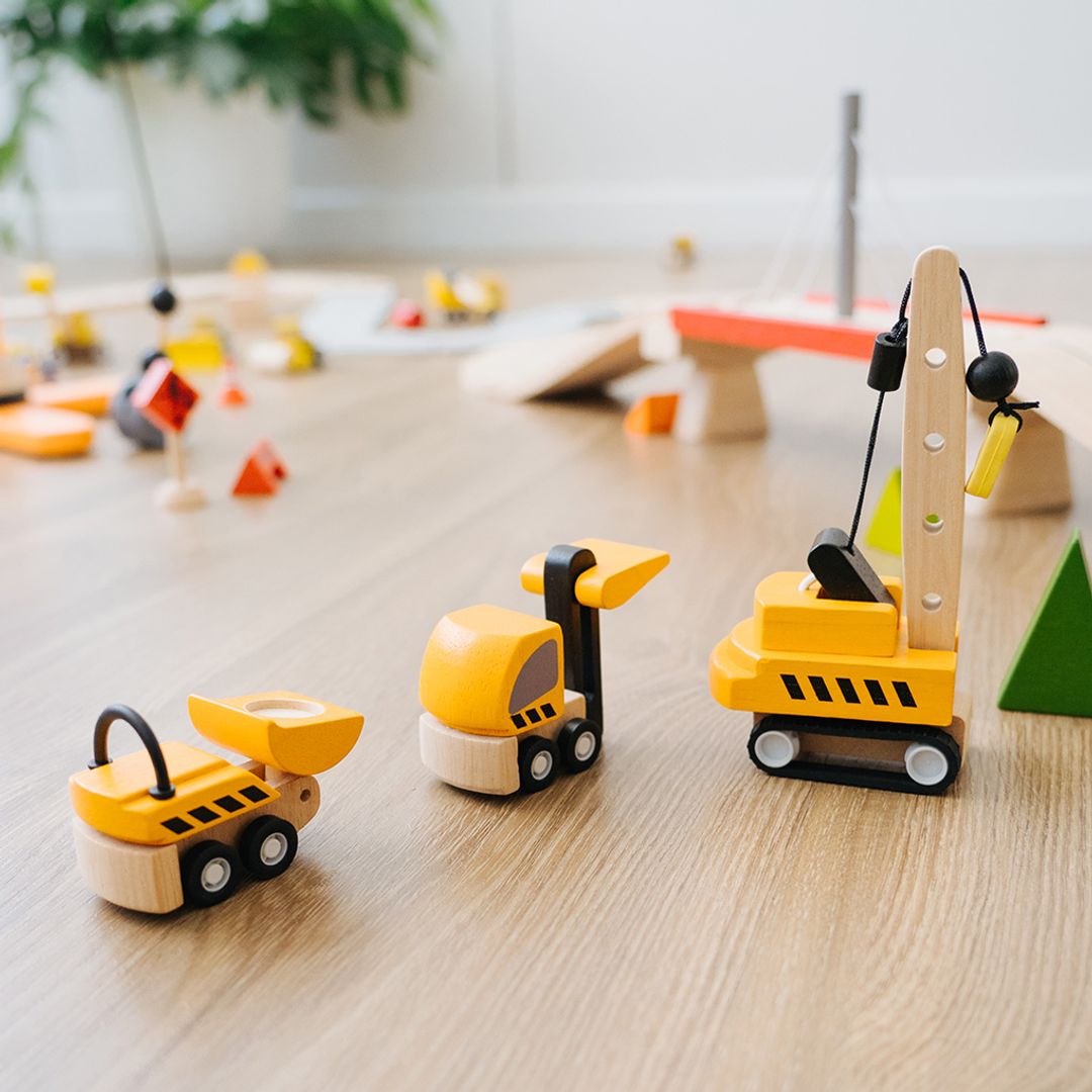 The full PlanToys wooden construction fleet lined up and ready for work on a playroom floor.