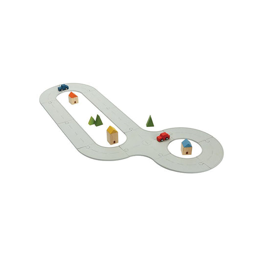The fully assembled PlanToys flexible rubber road and rail medium set featuring wooden cars, houses, and trees.