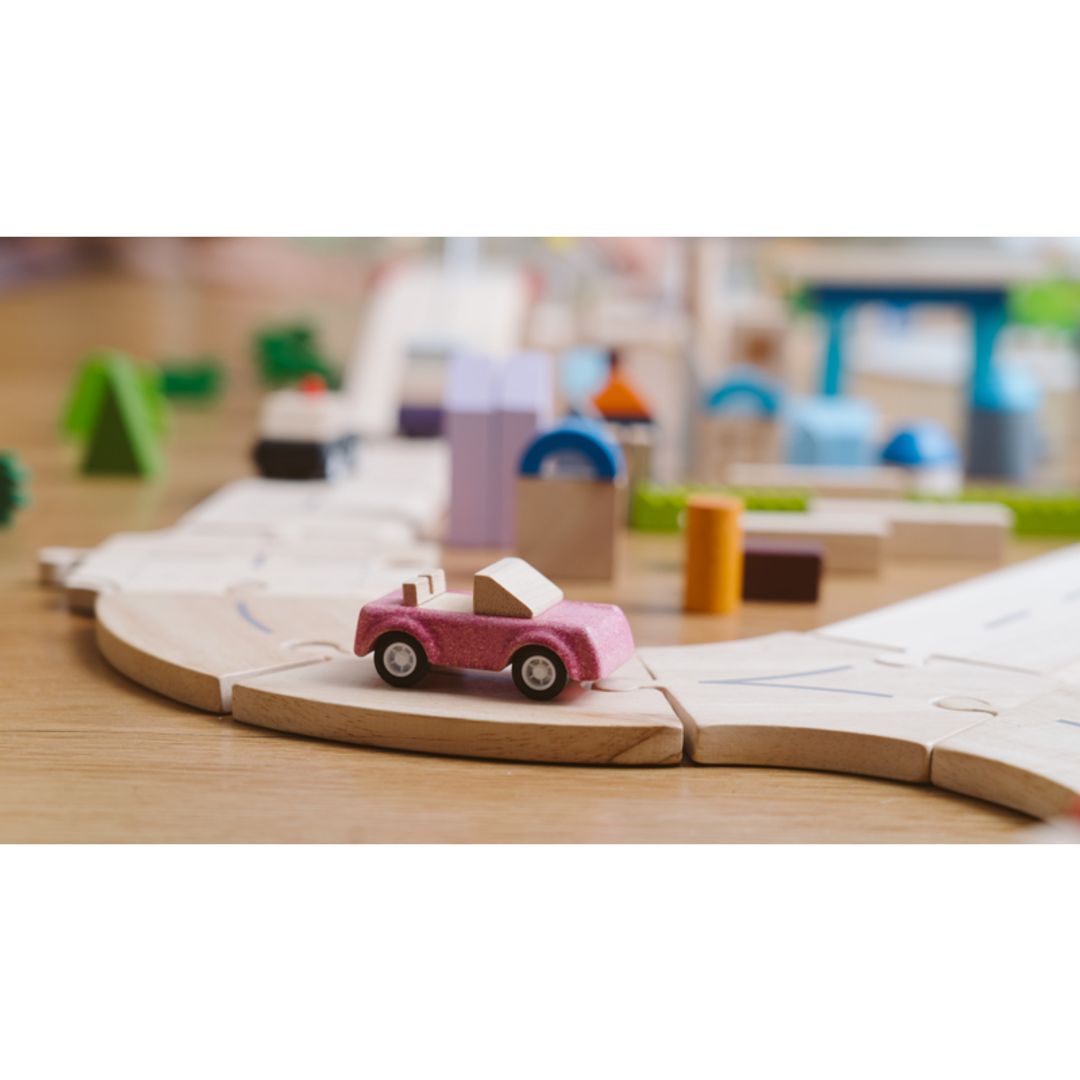 PlanToys wooden pink sports car across a child's wooden track.