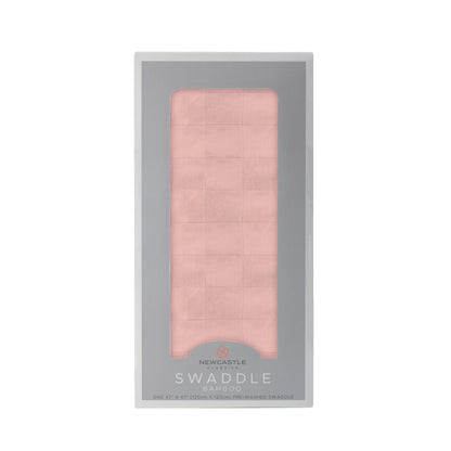 Straight front view of the packaged Pink Rose baby swaddle blanket inside a grey Newcastle Classics display box.