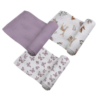 Top-down view of the three cotton muslin swaddle blankets partially unrolled, showcasing the solid lavender, purple butterfly, and woodland fawn prints.