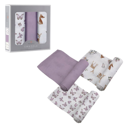 Three Newcastle Classics Mountain Meadow cotton muslin swaddle blankets partially unrolled next to their grey 3-pack window packaging box.