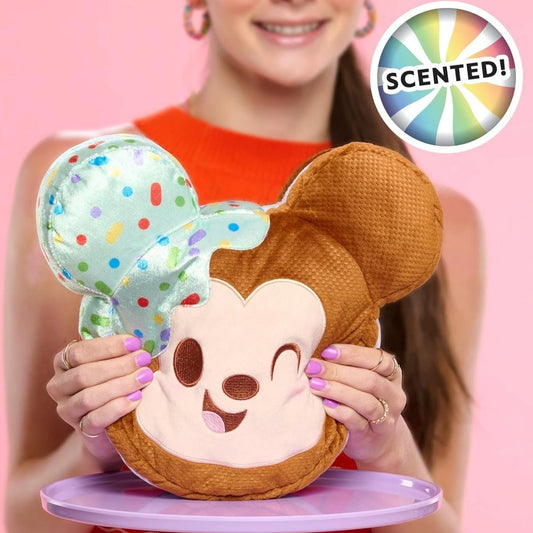 Lifestyle view of the mint-scented Disney Munchlings Mickey Mouse plush resting on a display stand, showcasing its fun food-inspired design.