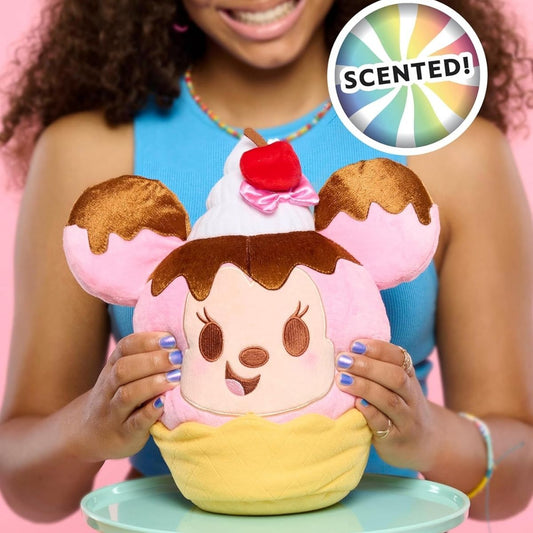 Lifestyle view of the scented Disney Munchlings Minnie Mouse plush resting on a display stand, showcasing its fun food-inspired design.