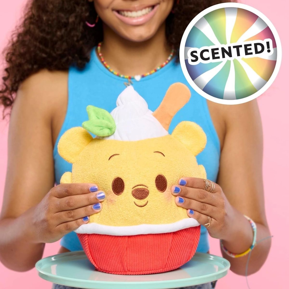 Lifestyle view of the lemon-scented Disney Munchlings Winnie the Pooh plush resting on a display stand, showcasing its fun food-inspired design.