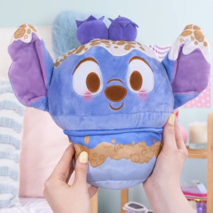 Lifestyle image showing a person's hands holding the ultra-squishy 10-inch Disney Munchlings Squeeze-A-Munch Stitch plush, highlighting its large, huggable size.