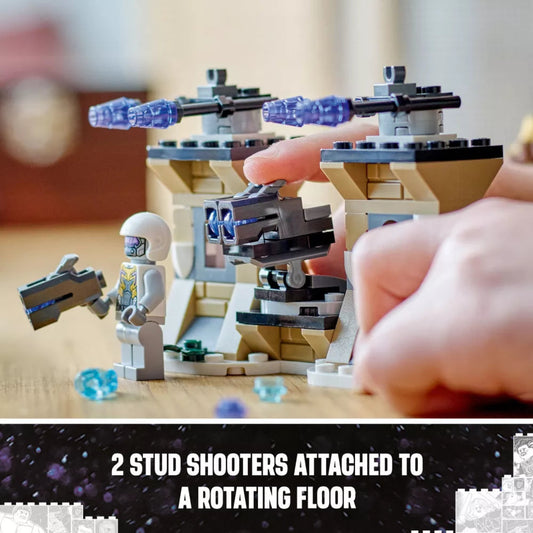 Close-up of a LEGO set with a rotating floor and stud shooters, held by a hand.