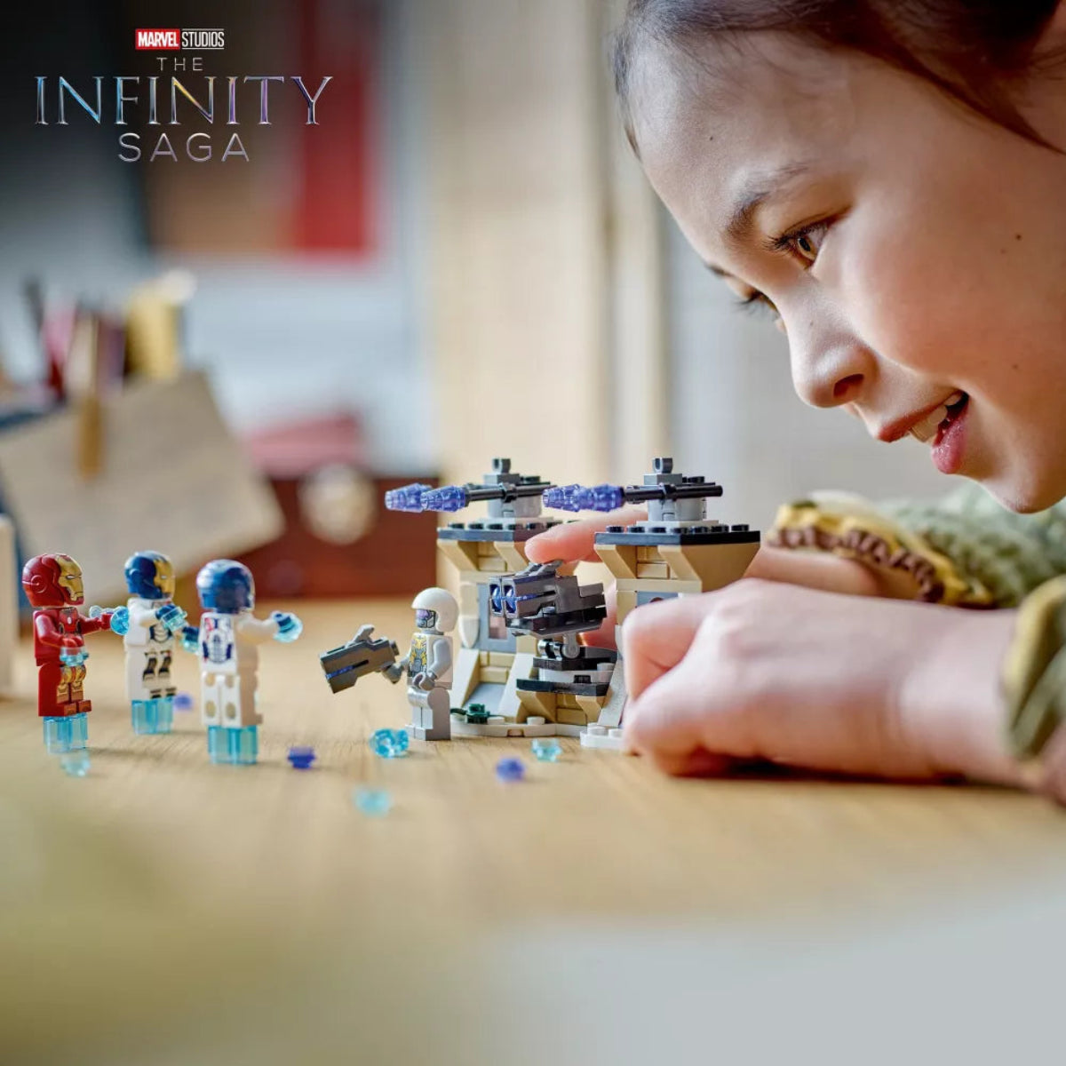 Child playing with Marvel Infinity Saga themed toy set on a table.