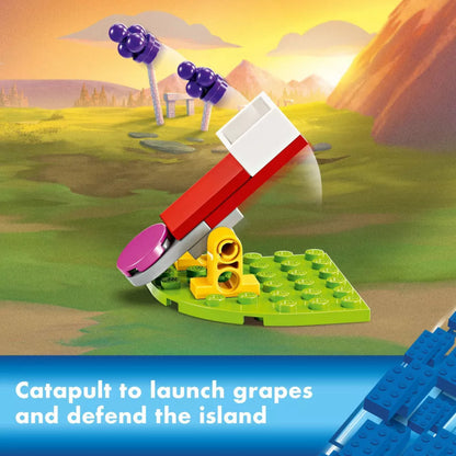 Toy catapult set on a grassy island with mountains in the background
