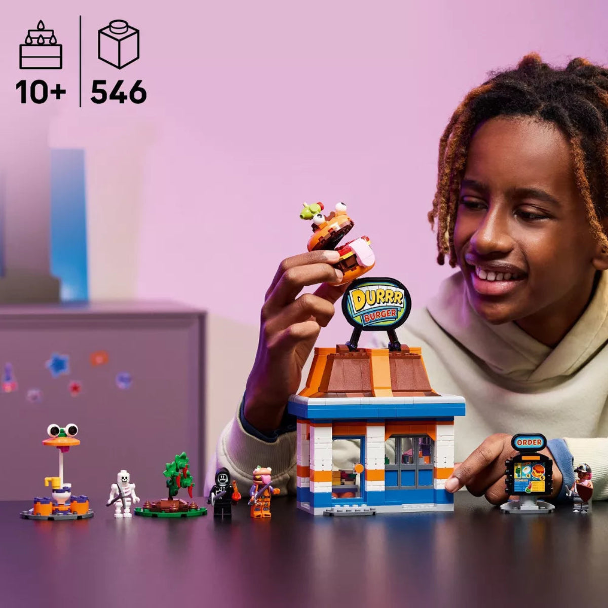 Child playing with a LEGO set featuring a Dubble Bubble store and characters on a purple background.