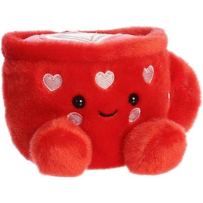Front angled view of the 5-inch Aurora Palm Pals Lotti Love Latte plush toy featuring a bright red mug with white embroidered hearts and a smiling face.