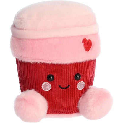 Straight front view of the sitting red and pink coffee cup plush showing its sweet embroidered face, rosy cheeks, and little pink feet.
