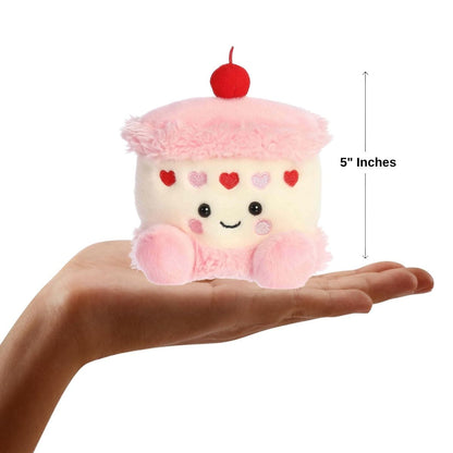 Dimension graphic showing the 5-inch Aurora Palm Pals Jubi Heart Cake resting comfortably in a person's hand.