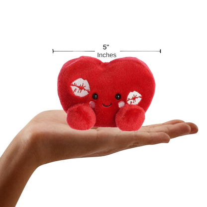 Sizing graphic showing the 5-inch Palm Pals Kimi Kisses Heart plush sitting perfectly in the palm of a hand to demonstrate its small scale.