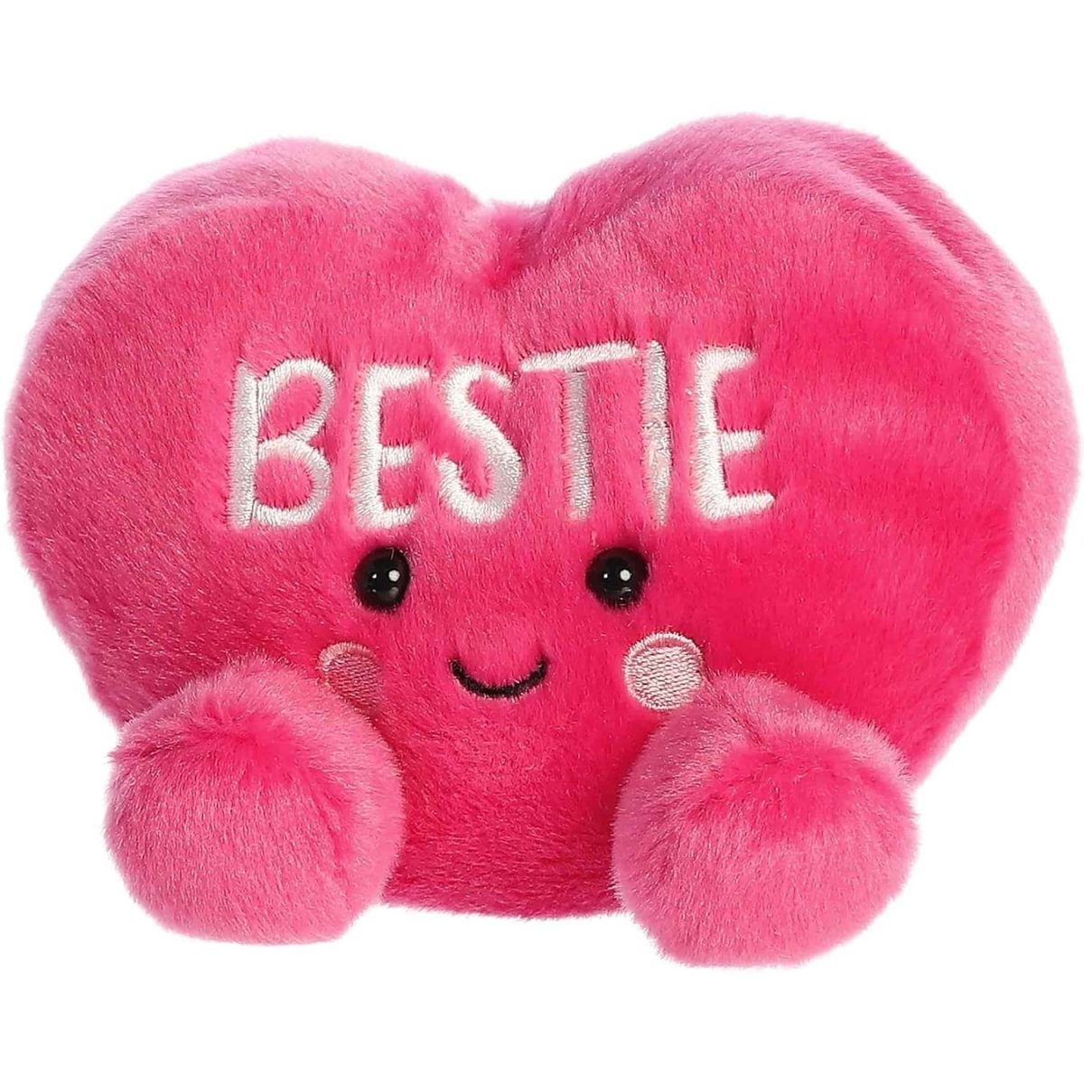 Angled front view of the smiling BESTIE plush heart sitting happily on its little plush bottom.
