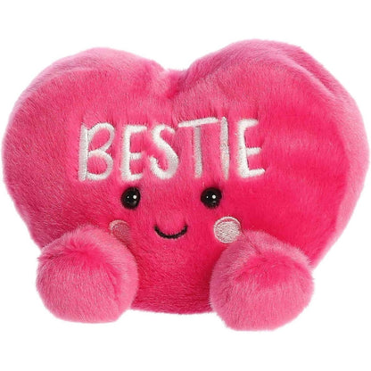 Angled front view of the smiling BESTIE plush heart sitting happily on its little plush bottom.