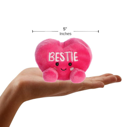 Sizing graphic showing the 5-inch Palm Pals Bestie Candy Heart plush sitting perfectly in the palm of a hand to demonstrate its small scale.